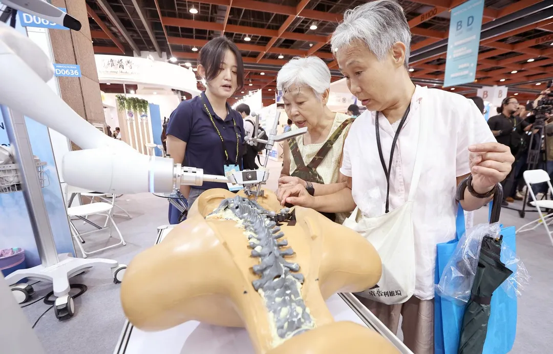 2026年「台灣醫療暨健康照護展（Medical Taiwan）」展出各式醫療器材、智慧醫療、穿戴式裝置、高齡照護及預防醫學等產品，民眾好奇地參觀微創手術機器人輔助平台。（圖／中時）