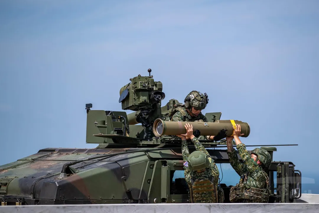 第542旅官兵為M1167拖式飛彈車補充拖式2B反裝甲飛彈彈筒。(圖/軍聞社)
