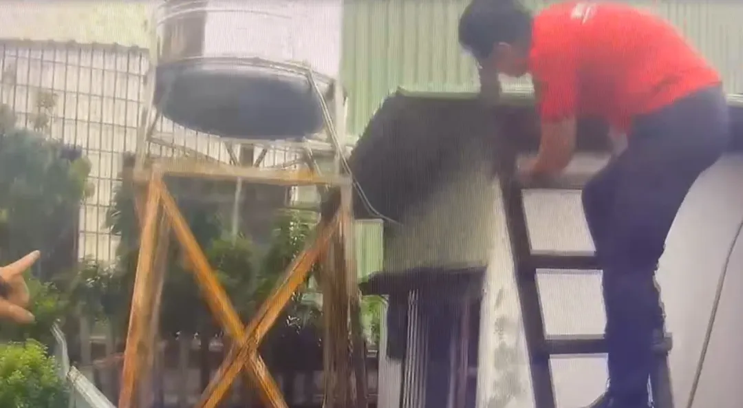 消防人員架設梯具後，全程陪同並協助該名男子緩慢移動，逐步爬出水塔脫困。（圖／嘉義市消防局提供）