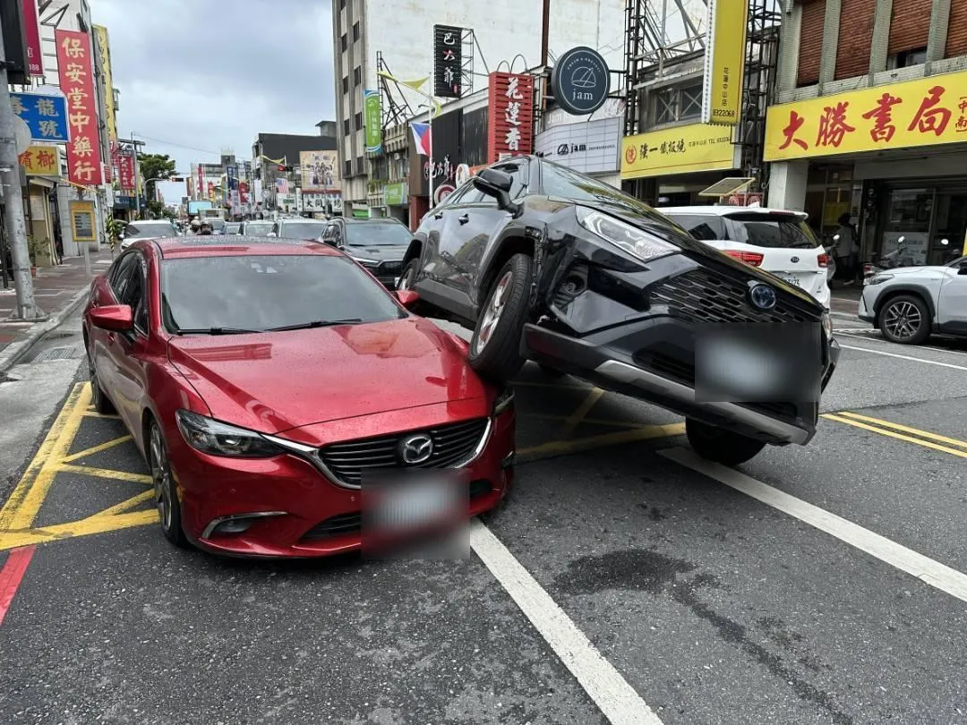 花蓮發生離奇車禍，黑色休旅車半個車身直接騎上紅色轎車，所幸2名駕駛均無傷。（圖／警方提供）