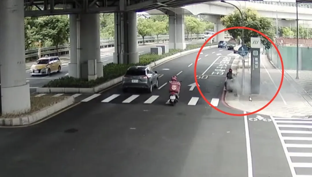 微型電動二輪車在捷運龍埔站前突然起火。(圖/翻攝畫面)