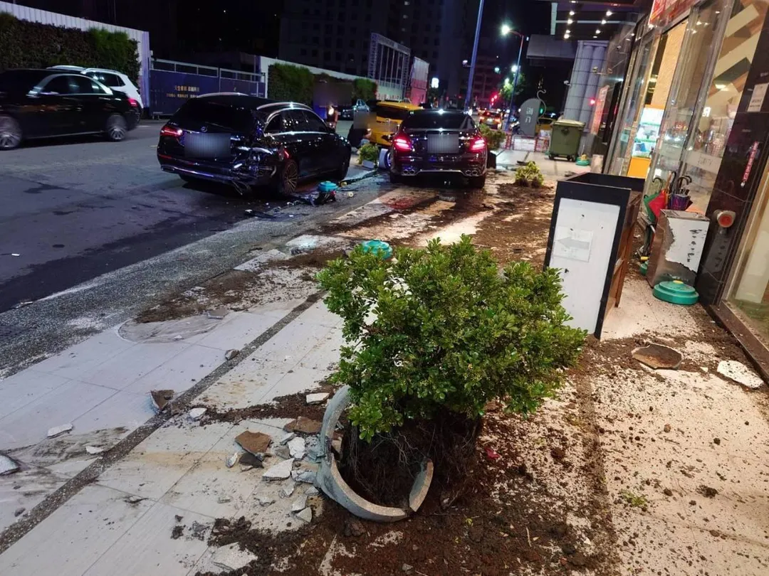 台中28歲顏男凌晨酒駕賓士，撞毀KTV前2部車與盆栽，現場一片狼藉。（圖／中天新聞）