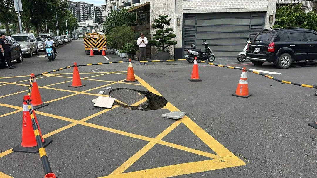 高雄路面驚傳「天坑」！人孔蓋瞬間傾斜下陷，警方急封鎖。（圖／翻攝自高雄市議員李雅靜臉書）