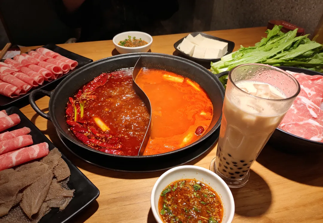 天氣熱吃麻辣鍋，再搭配冰涼手搖飲或冰品對腸胃較敏感，或本身有胃食道逆流、胃炎等問題的人來說，可能增加不適。（示意圖／AI生成圖）