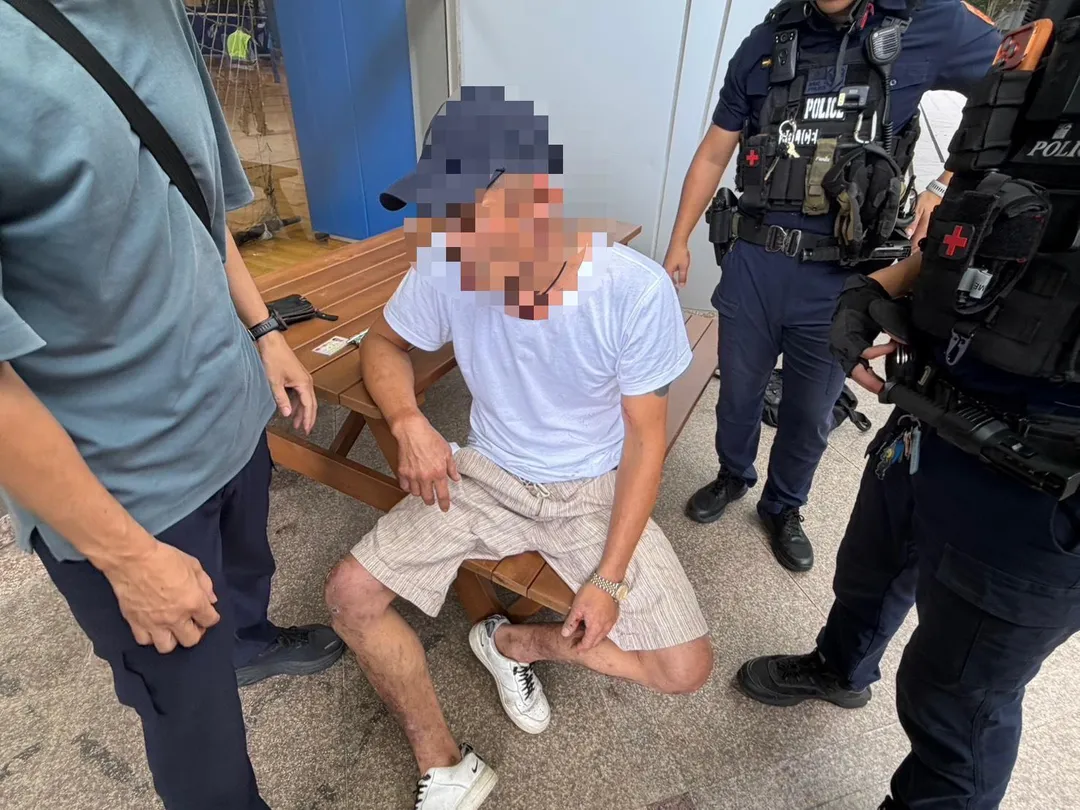 14日下午,一名身穿白衣、頭戴棒球帽的男子手持巨型園藝剪刀在淡江大學紹謨體育館前遊蕩,民眾發現後立即撥打110報案。(圖/警方提供)