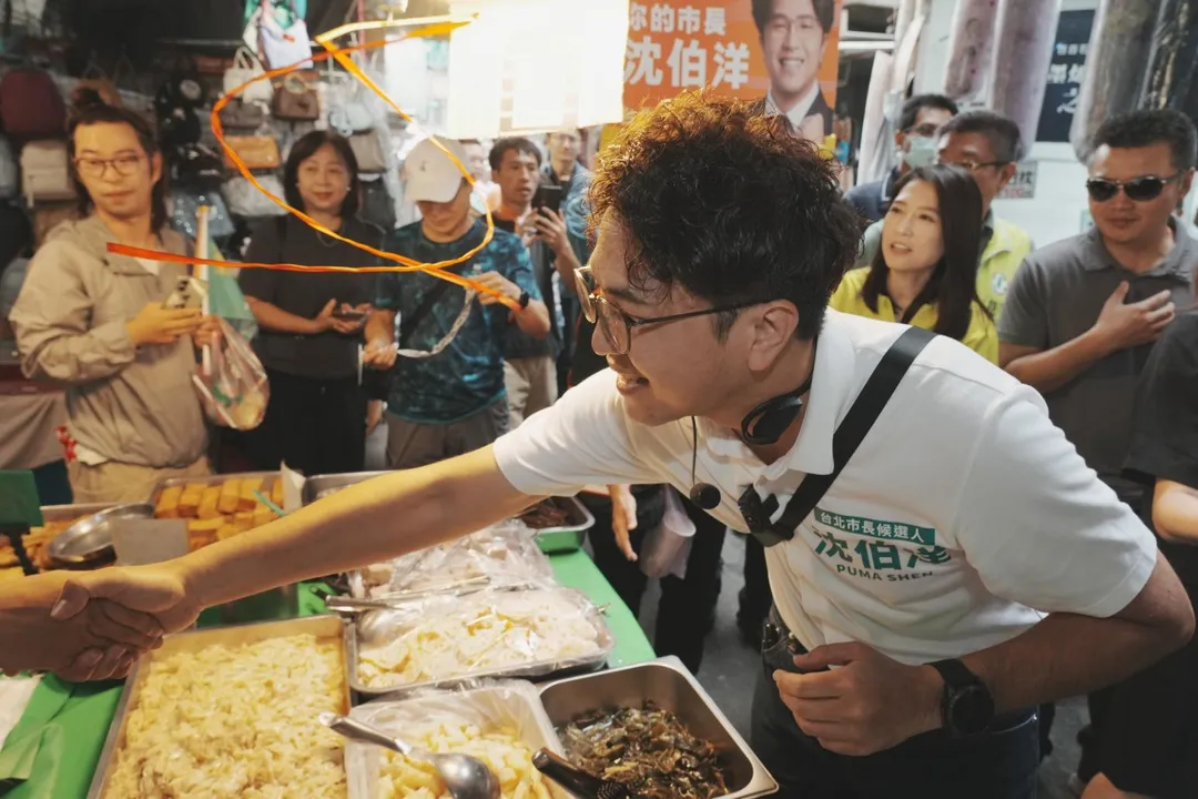 圖為沈伯洋在市場掃街拜票,和攤商握手。(圖/沈伯洋競辦提供)