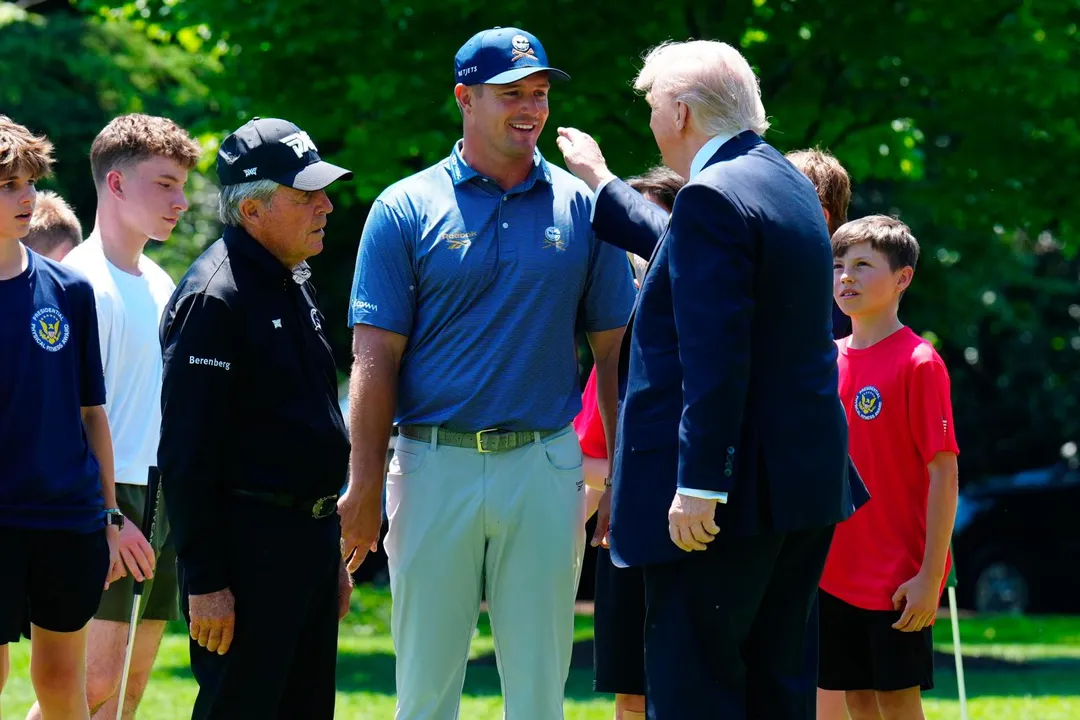 高球選手德尚博（中）今年5月在華府白宮草坪與美國總統川普（右）交談。（圖／美聯社）