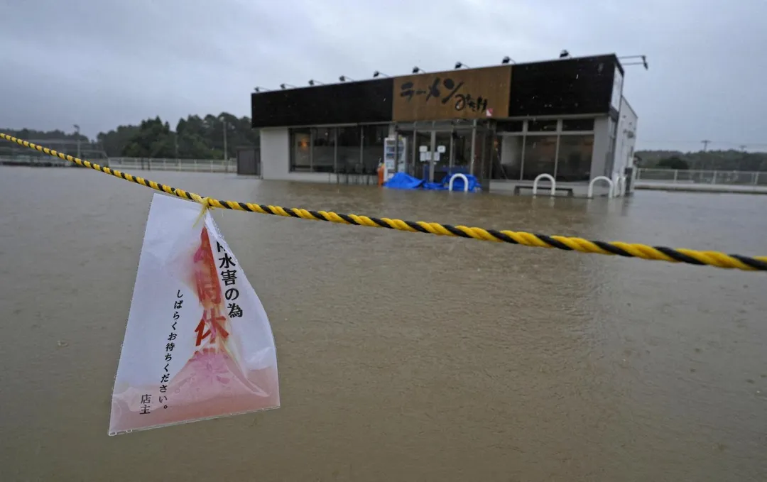 「杜鵑」颱風21日逼近日本千葉縣，暴雨導致一家拉麵店附近淹水，業者緊急掛出停業告示。（圖／路透社）