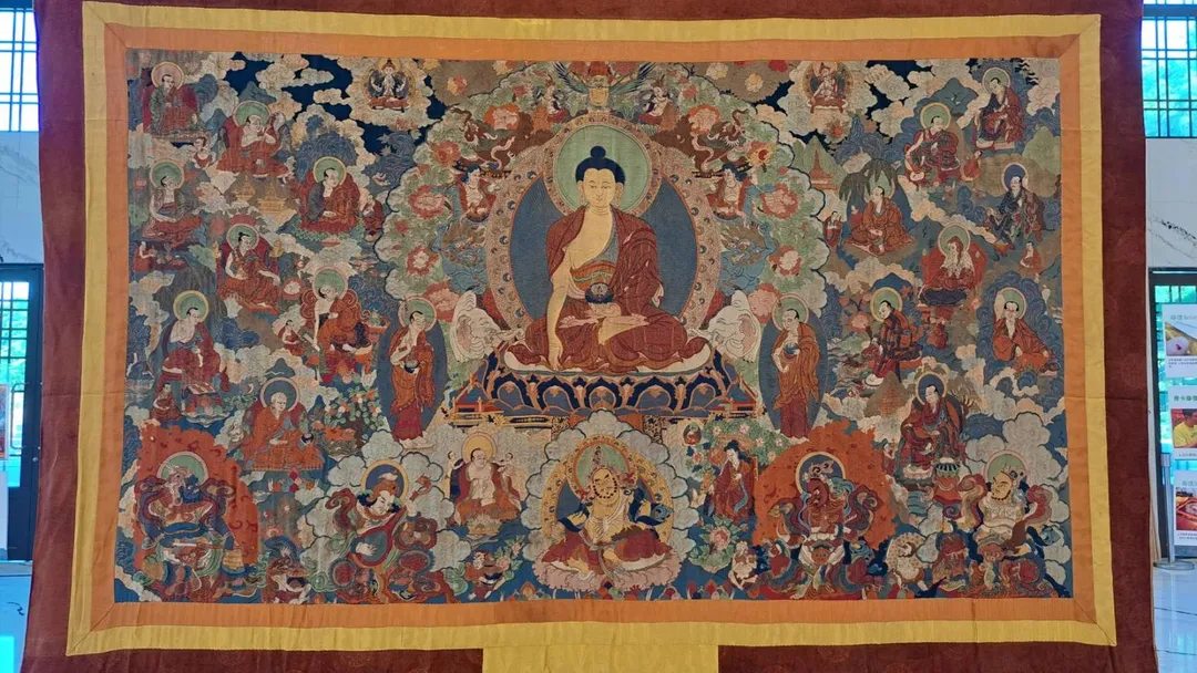 唐卡修復師陳宜達於記者會展出珍貴唐卡與佛教藝術織繡品,圖為清代「釋迦牟尼佛與十六羅漢」五彩織錦。(圖/弗利思特文化事業提供)