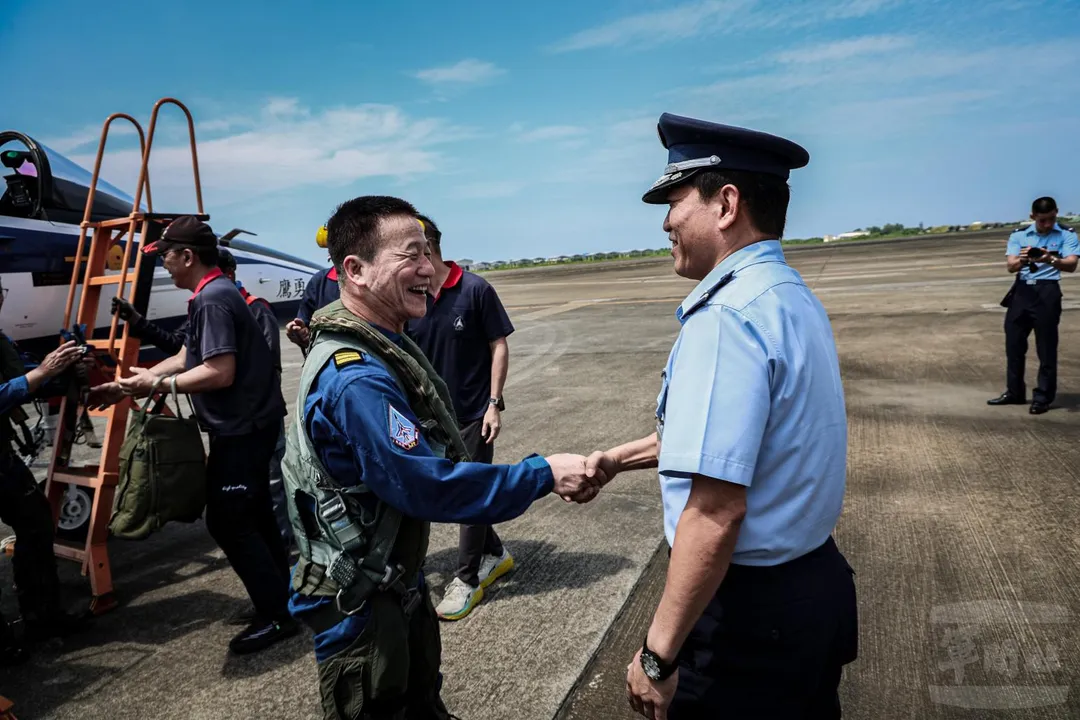 朱佳明(圖右)迎接1166號勇鷹號高教機降落後下機的曹進平。(圖/軍聞社)