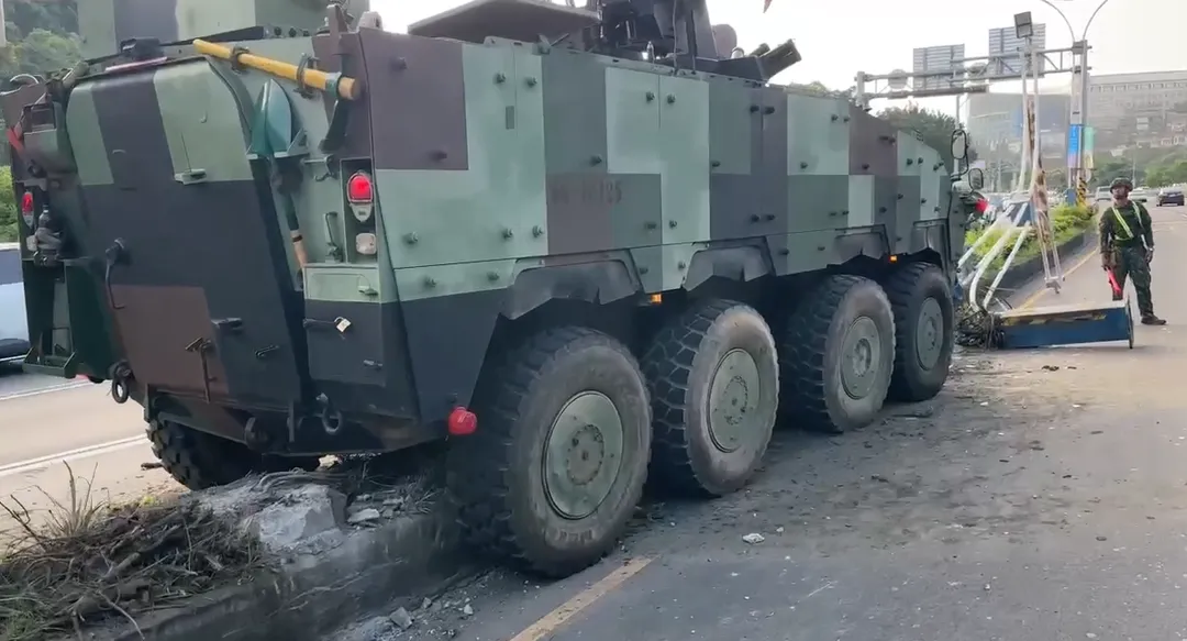 一輛國軍八輪甲車行經淡水區關渡大橋往台北方向時，不慎自撞分隔島，隨後撞斷路燈桿。（圖／警方提供）