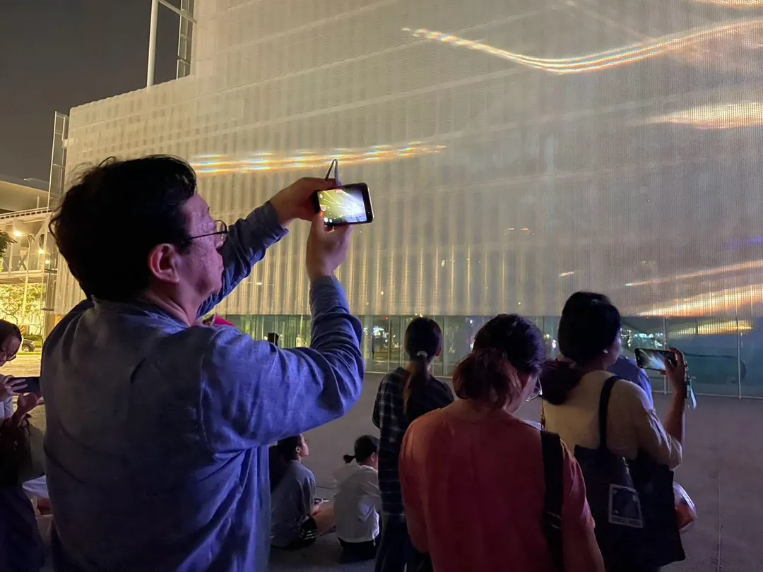 Sony集團首席技術長北野宏明觀賞《城市之鏡》展演,感受光影與建築交織的現場體驗。(圖/桃園市立美術館提供)