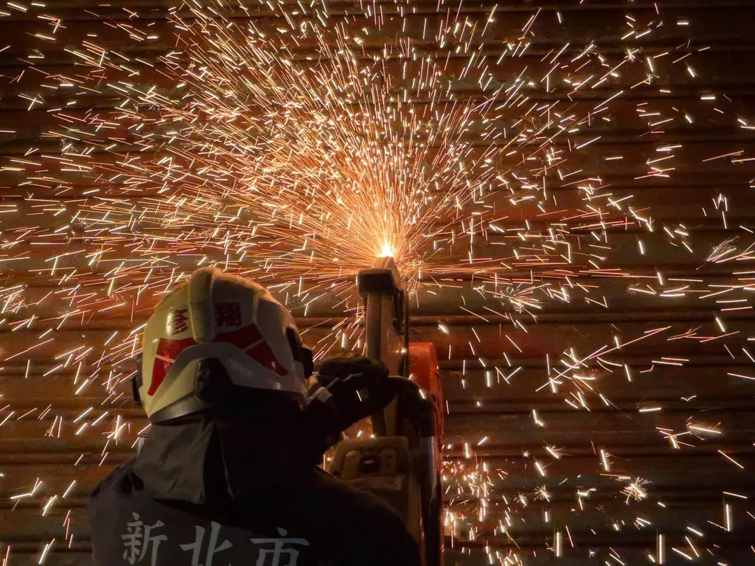警消鋸開鐵捲門。(圖/消防局提供)