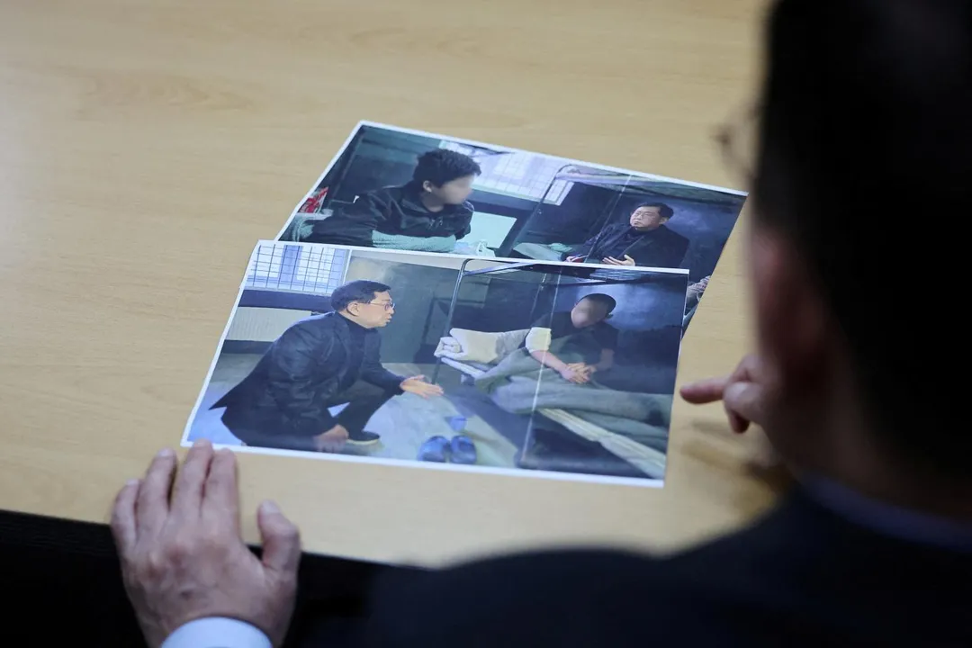 南韓國民力量黨議員俞勇源（Yu Yong-weon）在南韓首爾的國會辦公室內解釋照片：兩名近期從烏克蘭轉移至南韓的北韓戰俘。照片是他今年2月前往烏克蘭某戰俘營拍攝。照片來源已將兩名戰俘臉部進行模糊處理。（圖／路透）