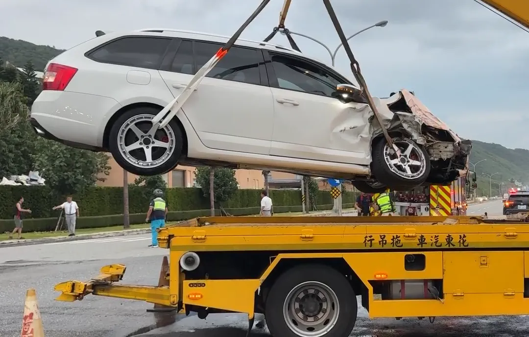 白色轎旅車車頭幾乎全爛，撞後彈至對向車道並冒出陣陣白煙，零件碎片散落一地。（圖／翻攝畫面）