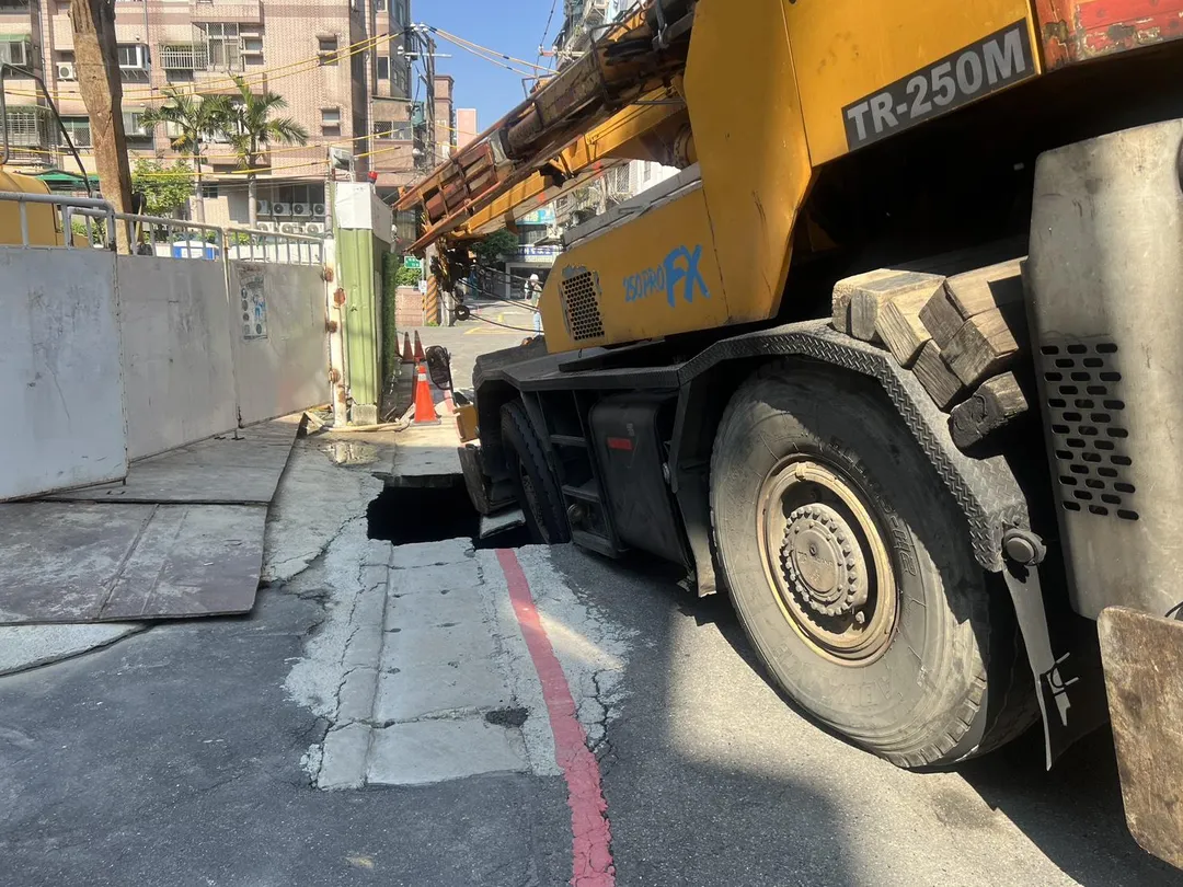 天坑現場,吊車後輪卡入大洞,畫面相當驚悚。(圖/警方提供)