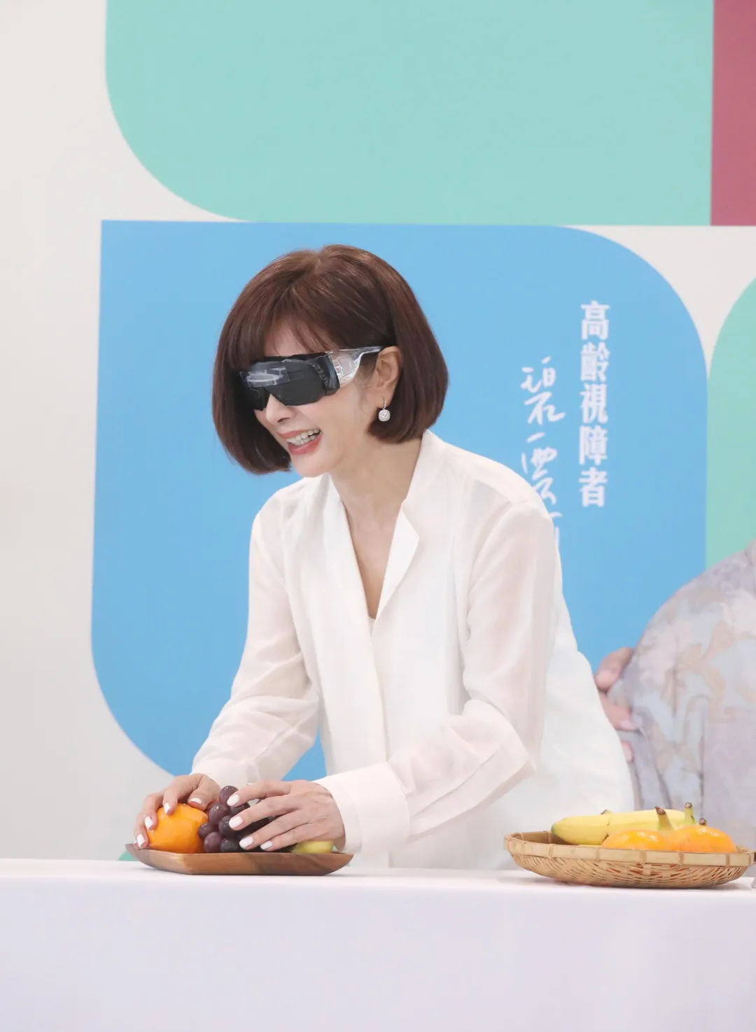 陳美鳳在活動中戴上視覺模擬眼鏡，體驗視障者的日常生活。（圖／愛盲基金會提供）