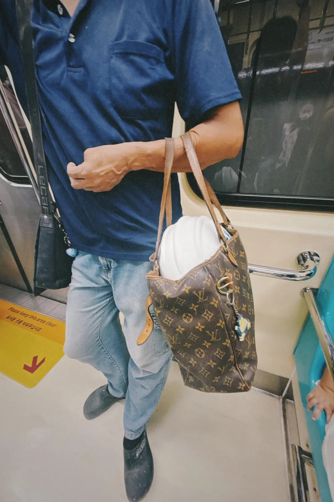 營建大哥在台北捷運車廂將安全帽壓在LV包上，引發討論。（圖／Threads@yyydessert授權使用）