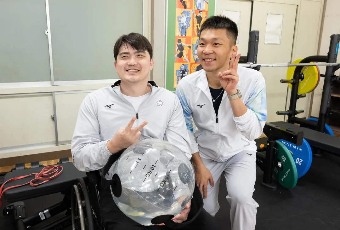 李洋與羽球選手董曉威合影,關心選手需求及備戰狀況。(圖/運動部提供)