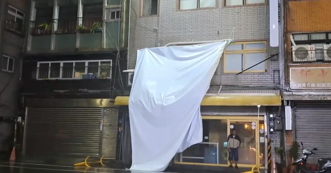 基隆市中正區正濱漁港內，一名候選人的看板布條被吹落並在現場飄搖。（圖／翻攝畫面）