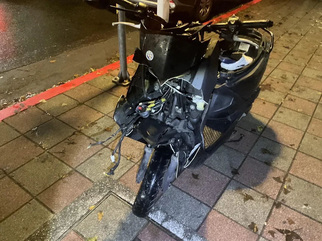 吳姓騎士機車遭猛烈撞擊，現場零件碎裂散落。（圖／警方提供）