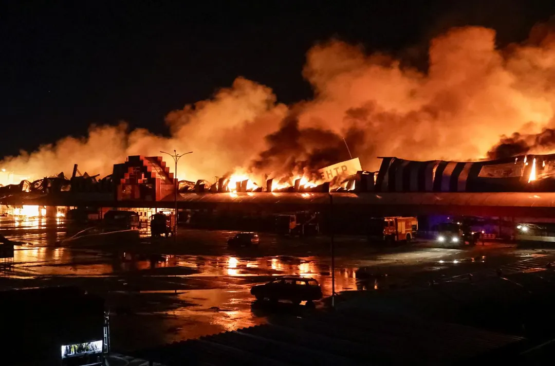 烏克蘭哈爾科夫一處購物中心遭襲擊燃燒，消防員24日緊急救援。（圖／路透社）