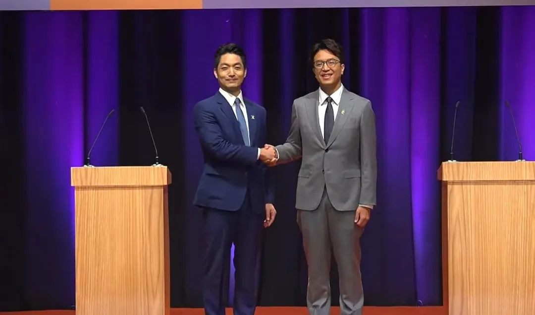 蔣萬安、沈伯洋31日抵辯論會場握手。（圖／TVBS提供）