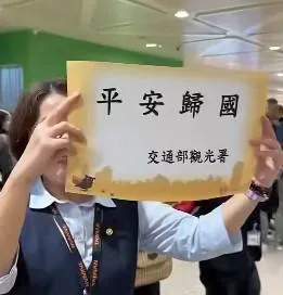 政府官員在桃園機場手持平安歸國迎接自中東地區自行前往他國機返台的民眾。（翻攝自臉書粉專鎖綠鴨提供影片）