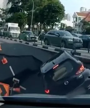 新加坡一處道路突現天坑,一輛驕車掉落洞裡。(圖/翻攝自X)