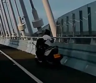 17日淡江大橋上1名重機騎士擅自停在快車道路肩拍照。（圖／翻攝畫面）