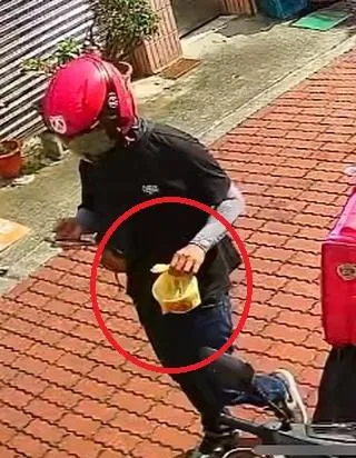 張先生家門外的監視器拍到外送員抵達時的狀況，黃色塑膠袋內的物品透出不明粉紅色。（圖／Threads@sha_sha_sha_shark授權提供）