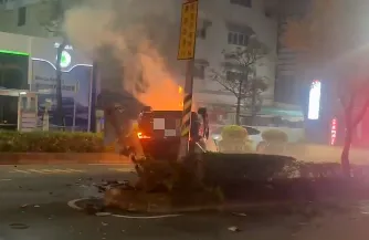 車輛自撞同向慢車道分隔島後翻覆於車道上，底盤朝天，還一度起火冒煙。（圖／中天新聞）