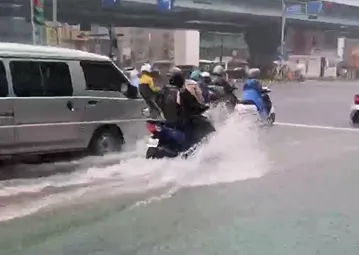 馬路在暴雨澆灌下，宛如一條小河，機車行駛過路面時，瞬間就揚起巨大水花。（圖／新北市議員參選人陳俊諺提供）