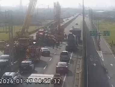事故現場共動員2輛吊車協助排除翻覆的水泥預拌車,警方已在現場進行交通疏導管制工作。由於水泥溢出佔用雙向內側車道及部分外側車道,造成台61線該路段雙向車流嚴重回堵。(圖 /翻攝畫面)