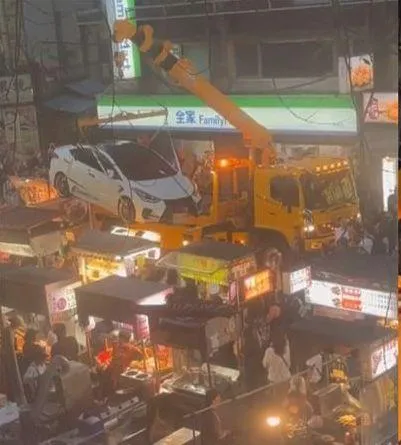 警方的「夾娃娃式拖吊」獲得在場民眾攤商一致歡呼。(圖/翻攝爆料公社)