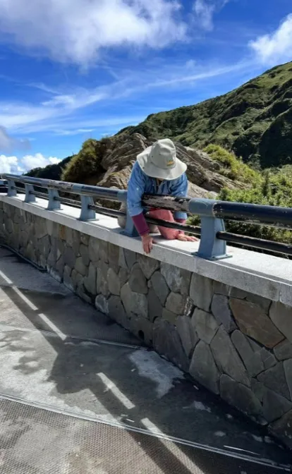 合歡山武嶺亭大媽為了拍美照，不顧危險翻過圍欄。（圖／翻攝自爆料公社）