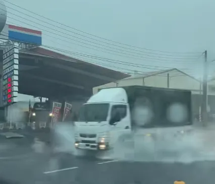 開車經過積水道路濺起水花。（圖／翻攝自{仁武人}※大小事臉書公開社團）