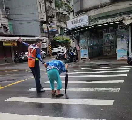 由於左右方持續有車輛通過，清潔隊員協助舉手示意有行人通行。（圖／翻攝自Facebook@我是土城人）