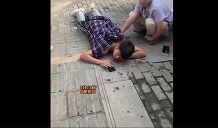喊痛也沒用！重慶男子街頭遭捅　趴地淡定刷手機等救援