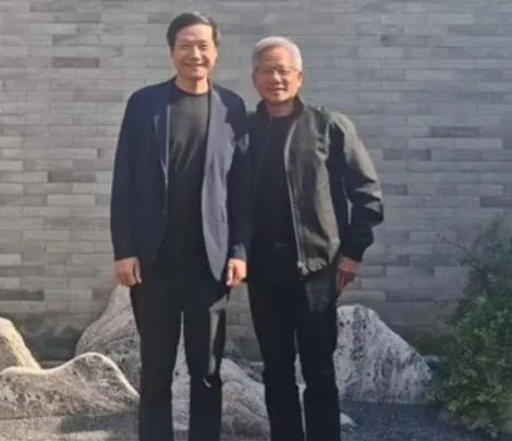 黃仁勳（右）酷暑下仍一身招牌皮衣與雷軍（左）合影。（圖/翻攝《網易》）