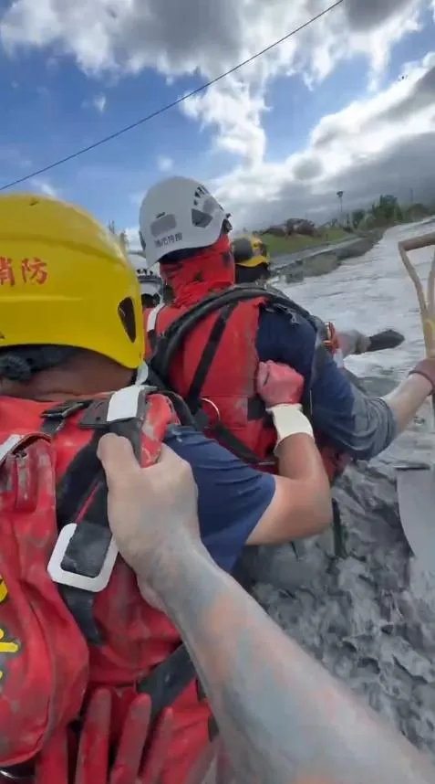由於急流水深及腰，水流湍急，特搜隊員和國軍弟兄，一個搭著一個渡河。（圖/高雄市消防局提供）