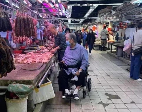 洪金寶坐輪椅市場買畫面曝光。(圖/翻攝自微博)