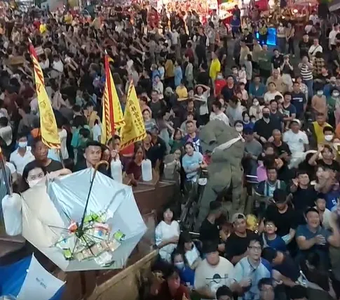 高雄小港鳳林宮超霸氣，中元普渡送信眾價值12萬的洋酒，民眾帶雨傘來接。（圖/翻攝臉書）