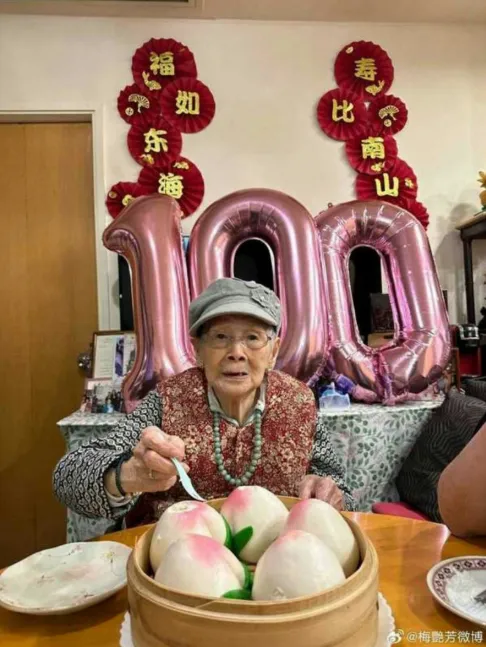 覃美金2年前吃壽桃慶祝100歲生日。(圖/翻攝自微博)