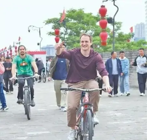 外國遊客在陝西西安城牆上騎車遊覽。（圖／新華社）