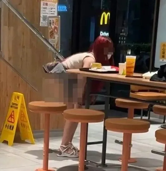 紅髮女確認周邊沒有其他人後，伸手脫下黑色內褲拍照。（圖／翻攝網路）