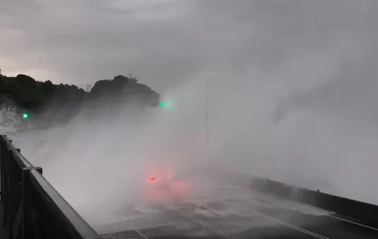 北台灣受白海豚颱風外圍環流影響,瑞芳陰陽海掀起巨浪,一輛特斯拉行經時慘遭吞噬。(圖/翻攝自threads)