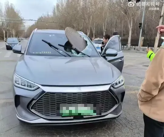人孔蓋炸飛砸中一輛車的擋風玻璃。（圖／翻攝微博）