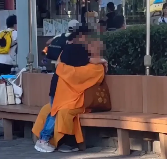 站立女子張望了一下,接著低頭與光頭男熱情擁吻。(圖/翻攝自Facebook@爆料公社二社)