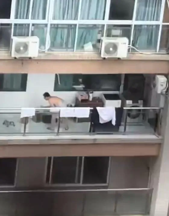 李男被拍到在住家陽台毆打寵物。(圖/翻攝微博)